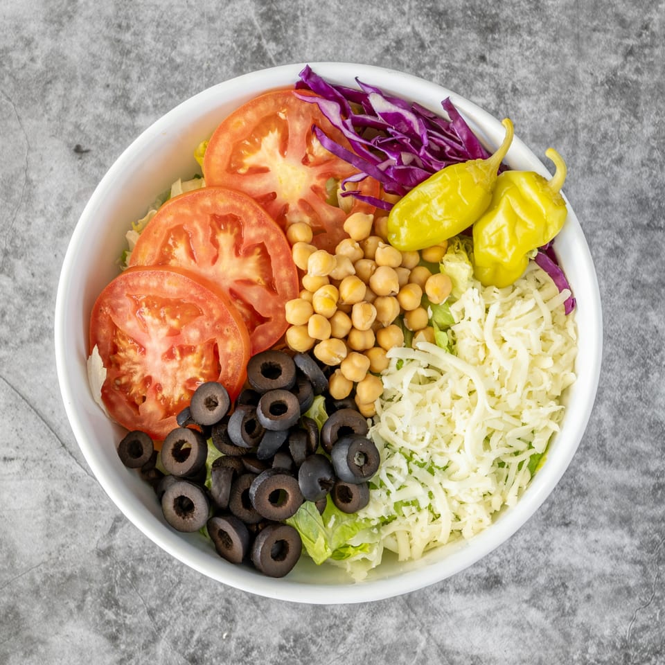 Ameci Pizza & Pasta's Italian salad with tomatoes, chickpeas, olives, shredded cheese, and peppers.